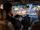 Intérieur réaliste d’un taxi à Kaboul au crépuscule, avec un chauffeur concentré vu de dos, un autoradio discret et des rues encombrées visibles par le pare-brise.